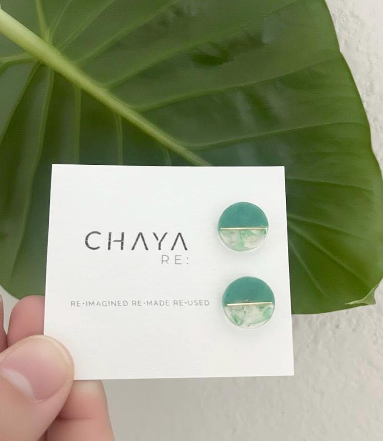 Green earrings on a Chaya card with a leaf background