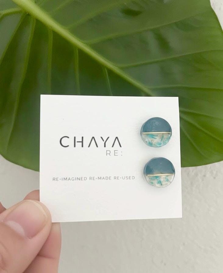 Blue earrings on a 'Chaya Re' branded card with green leaves in the background