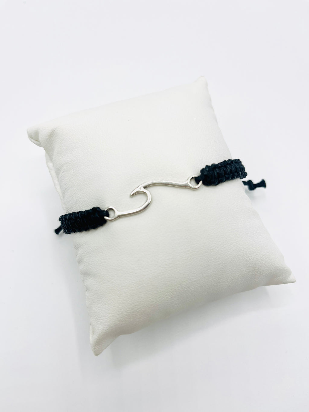 Black and silver bracelet on a white pillow